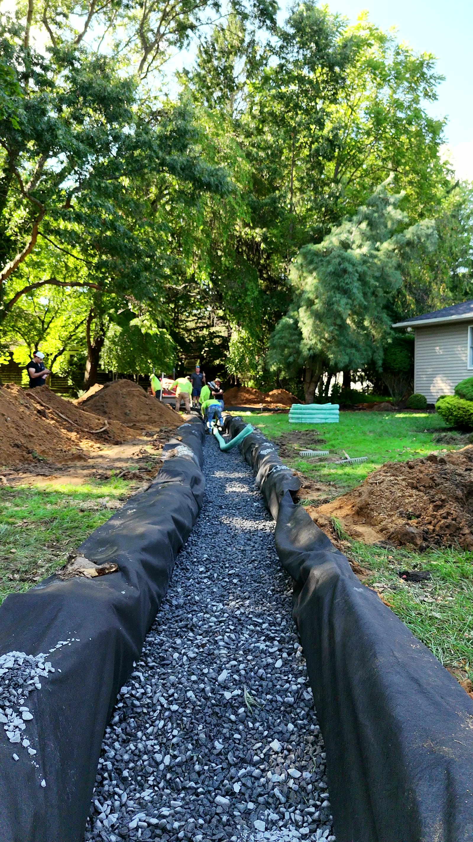 Aerial view of a drainage trench lined with fabric and filled with clean stone behind a house in Middletown, NJ