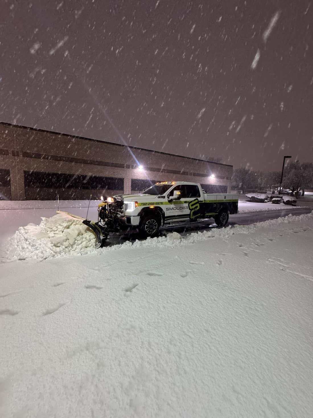 Plow truck clearing a commercial lot